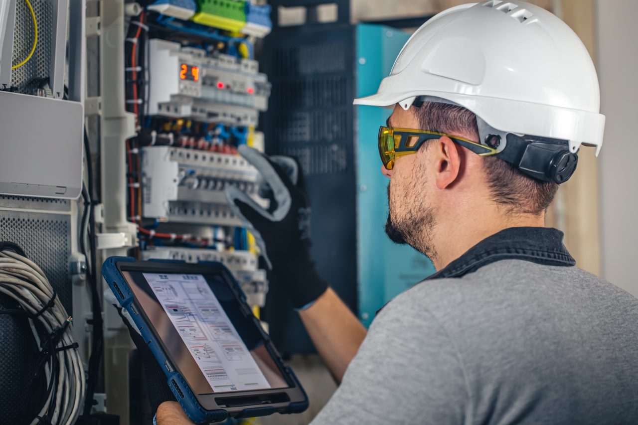 man an electrical technician working in a switchboard with fuses